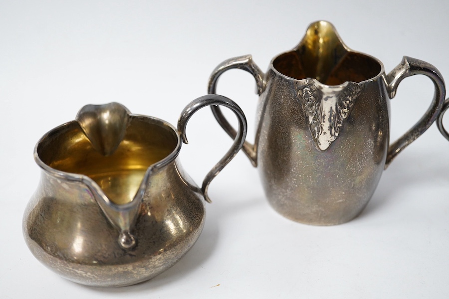 A Victorian silver double lipped cream jug by R & S Garrard & Co, London 1865, height 80mm, together with three other Victorian silver double lipped cream jugs, two by F.B Thomas & Co and one by George Fox, 17.7oz. Condi